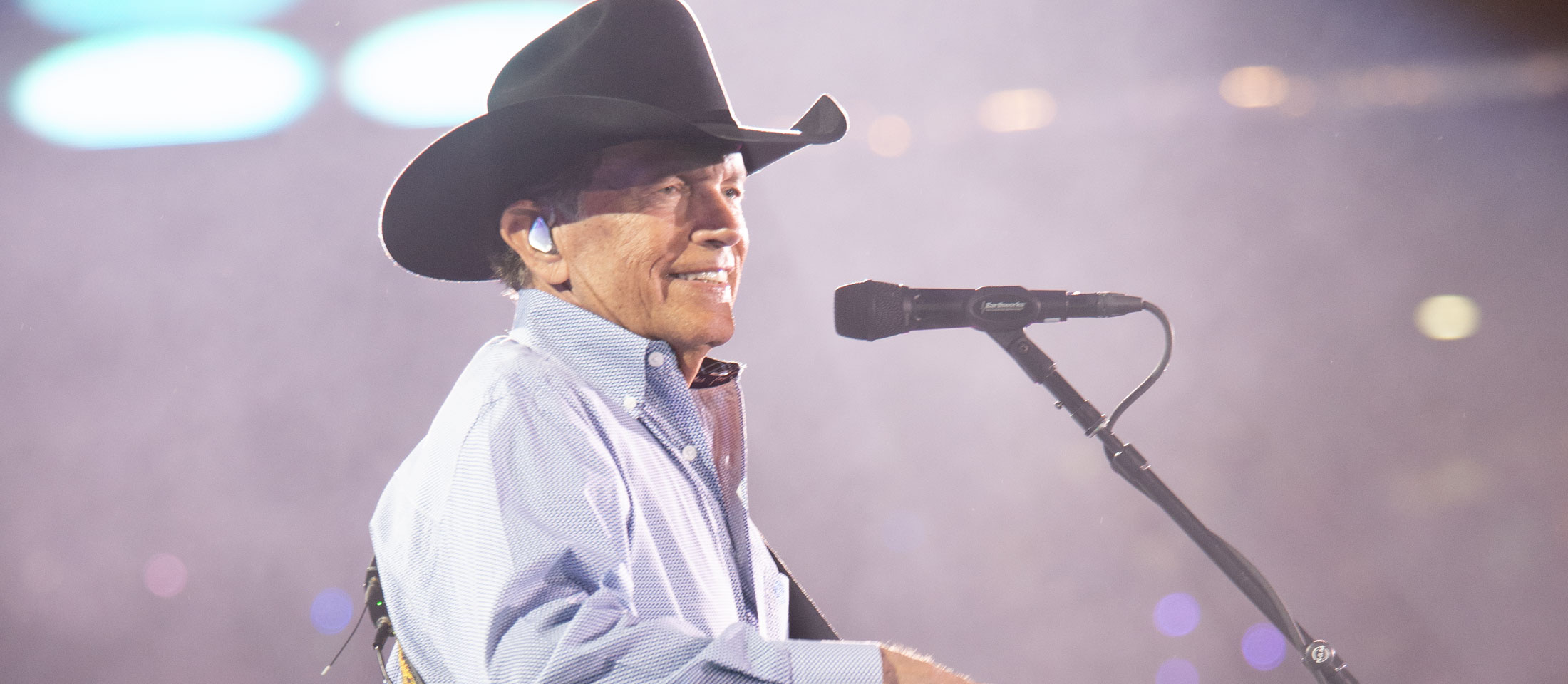 George Strait Playing guitar on stage.